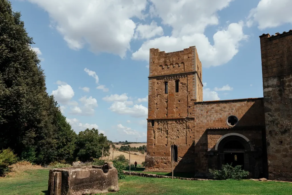 Exterior of the church, a large stone building in the middle of a grassy field.