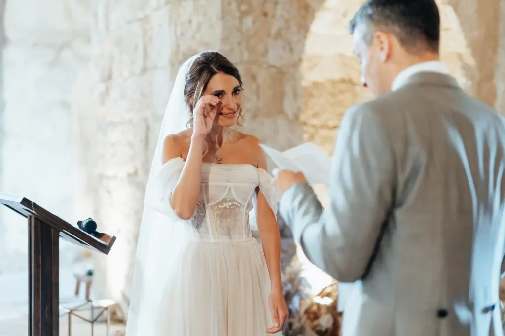 Bride wipes away a tear during the reading of wedding vows