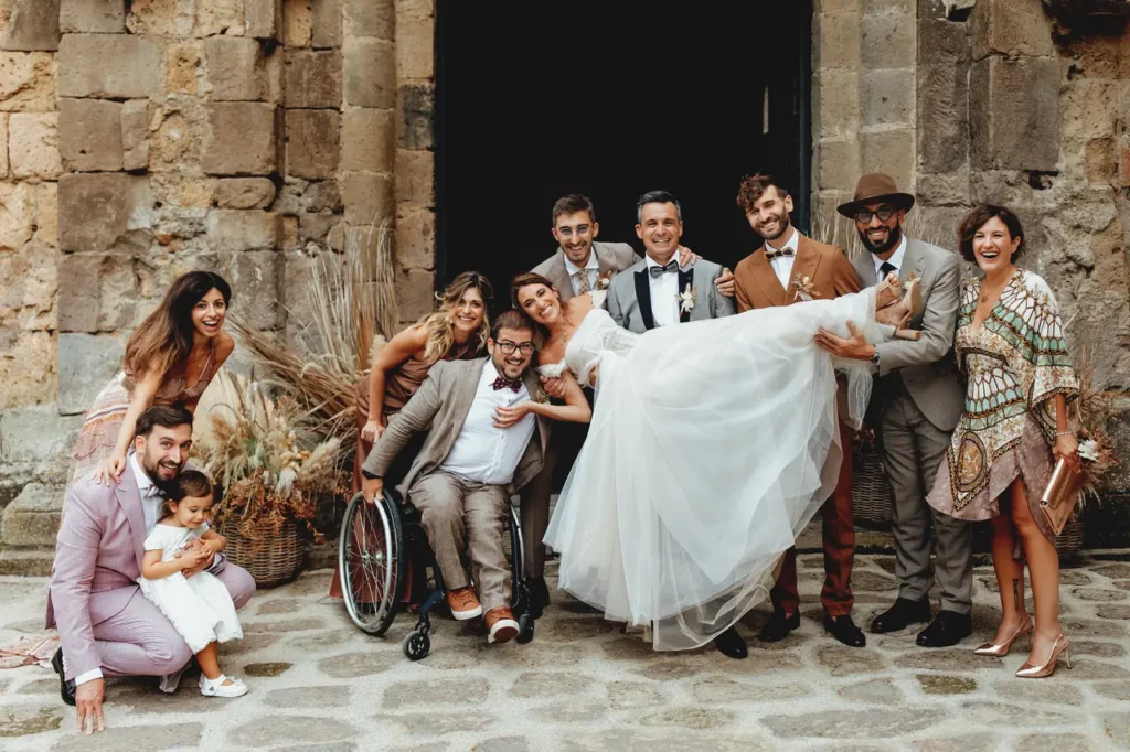 The bride and groom and some guests posing for a photo in front of the church of San Giusto Abbey