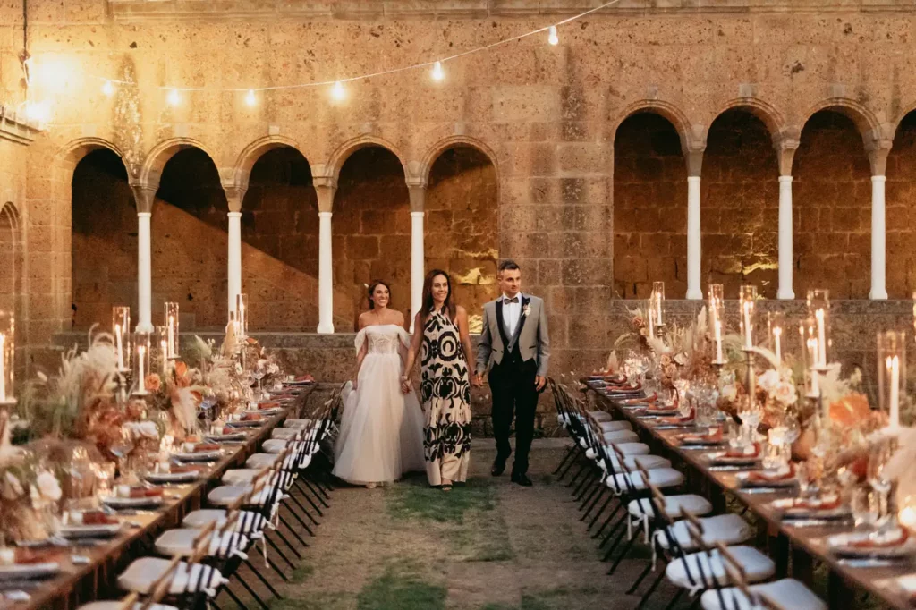 The bride and groom, accompanied by wedding planner simona celani, happily admire the reception set-up