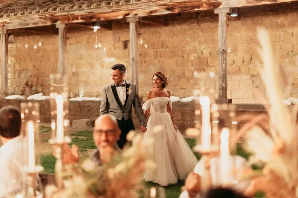 The bride and groom walk down the aisle during the wedding reception.