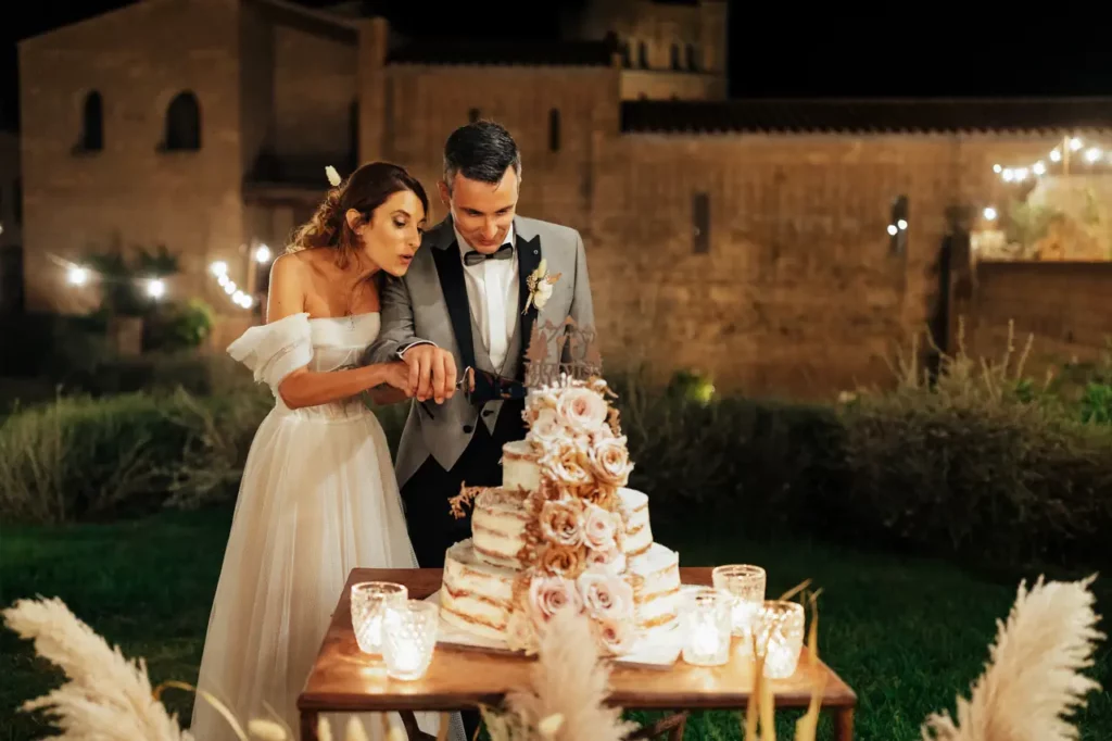 Gli sposi eseguono il tradizionale taglio della torta durante il loro ricevimento di nozze.