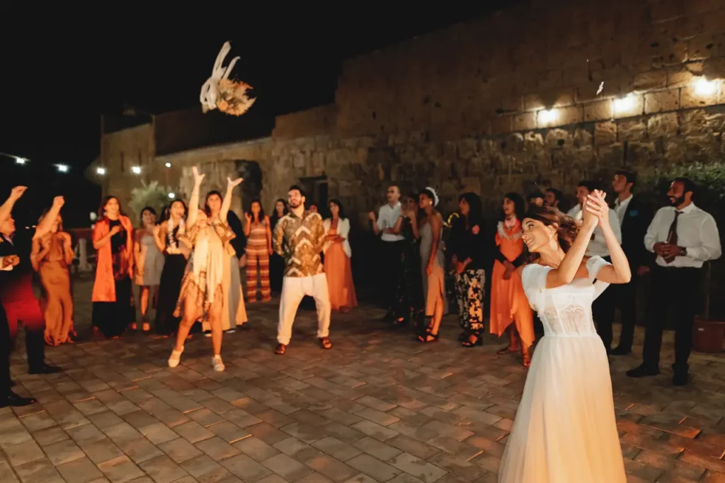 The bride performs the traditional throwing of the bouquet during the wedding party.