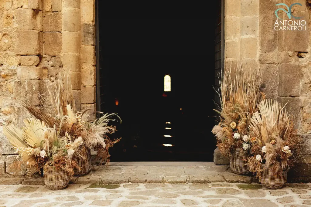 l'ingresso alla chiesa a navata unica dell'Abbazia di San Giusto adornata con composizioni floreali