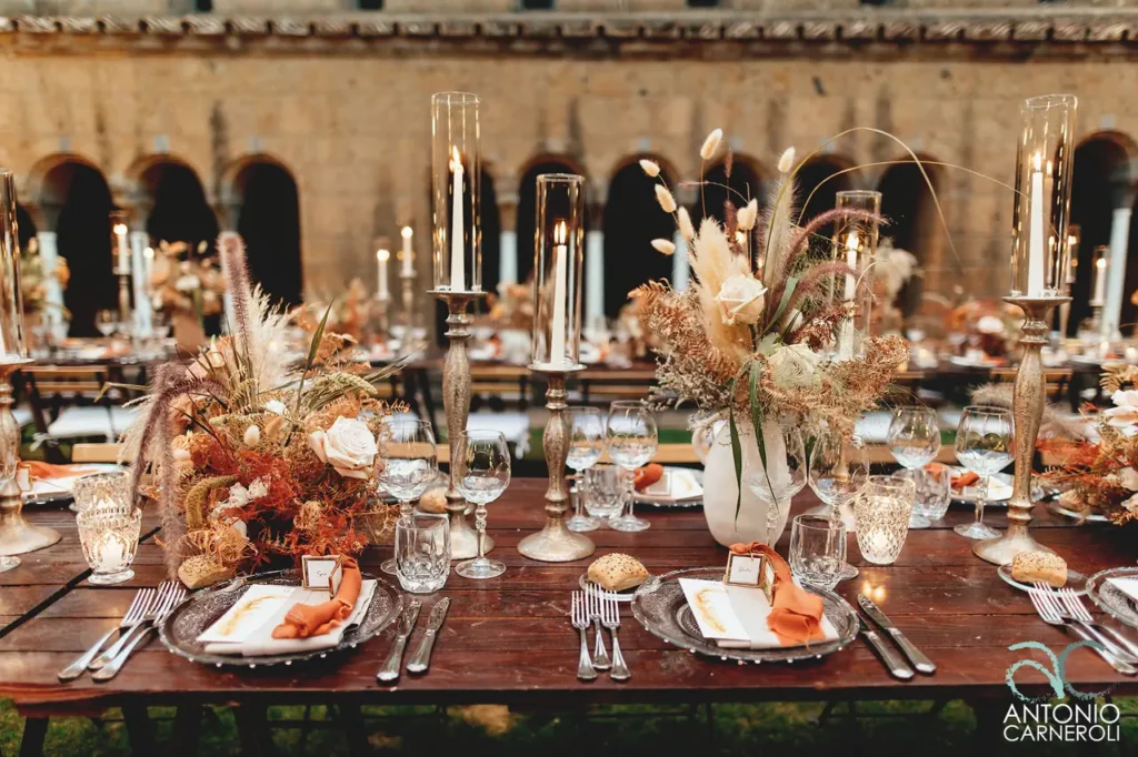 Una tavola splendidamente apparecchiata e adornata con candele e fiori.