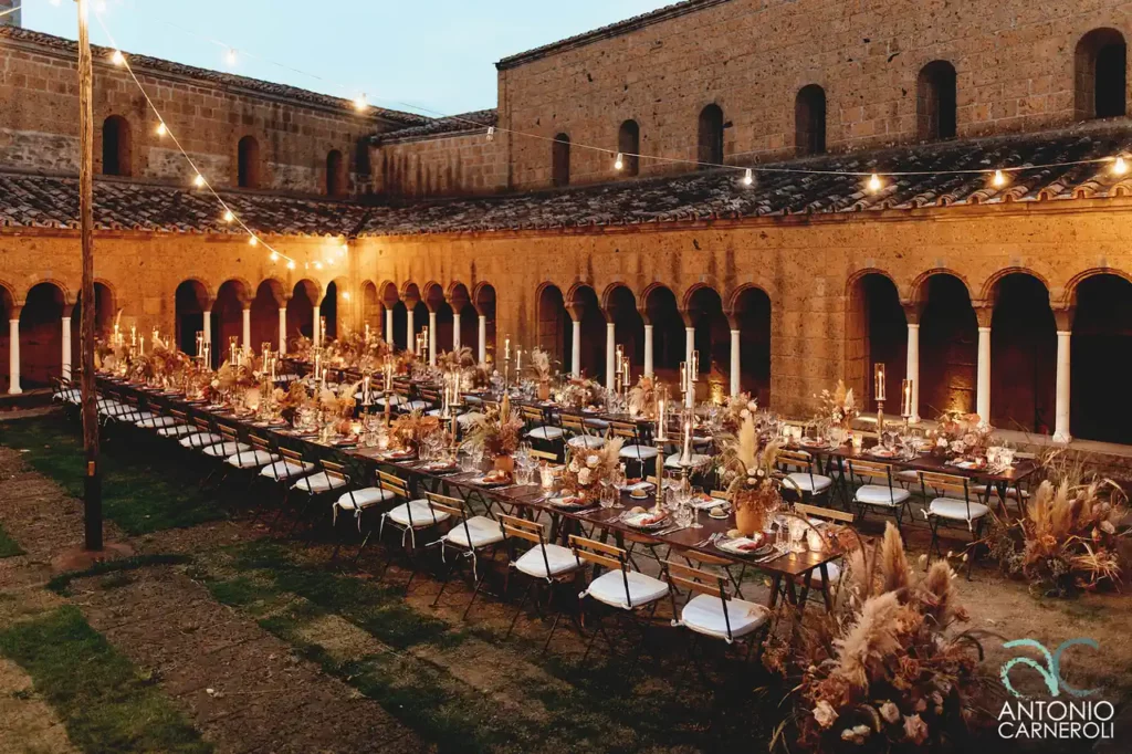 Preparation of the wedding reception tables beautifully set up in the courtyard of San Giusto Abbey