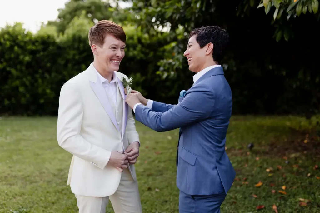 The groom, left, gets help putting a flower in his buttonhole.