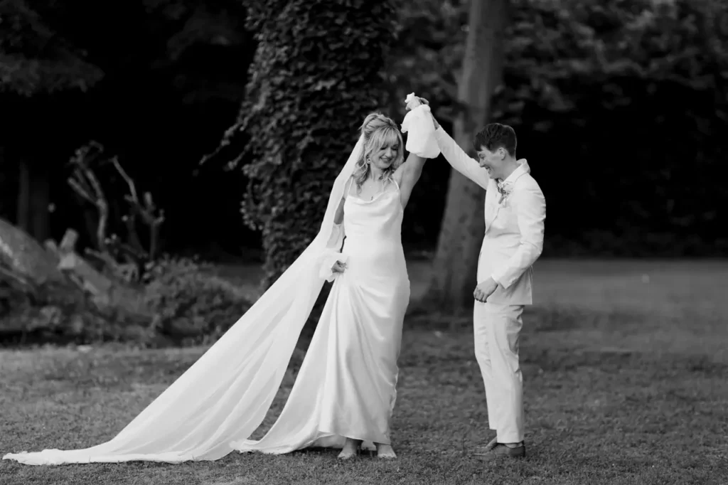 A bride and groom dancing outdoors in black and white photography.