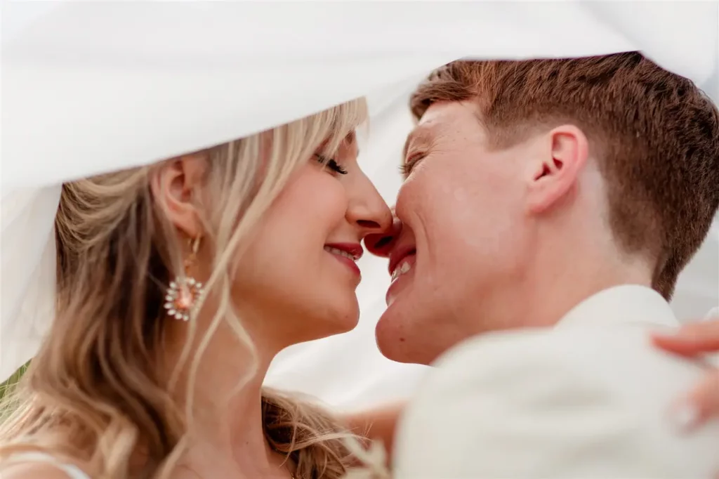 Intimate Wedding at Villa Elena: A joyful couple sharing an intimate moment under a veil.