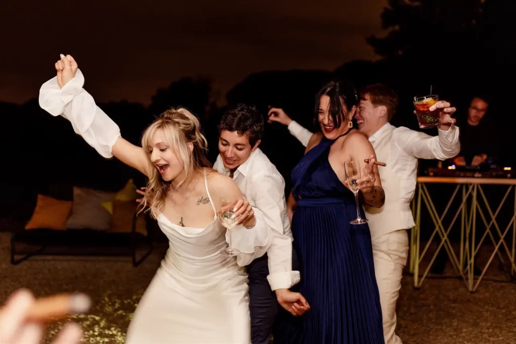 The bride and groom, together with a group of joyful people, dance and celebrate during the wedding reception.