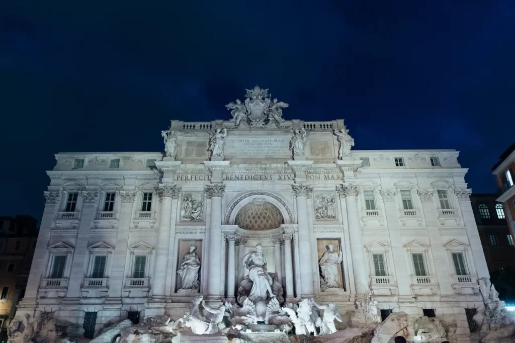 The trevi fountain in rome illuminated at dawn.