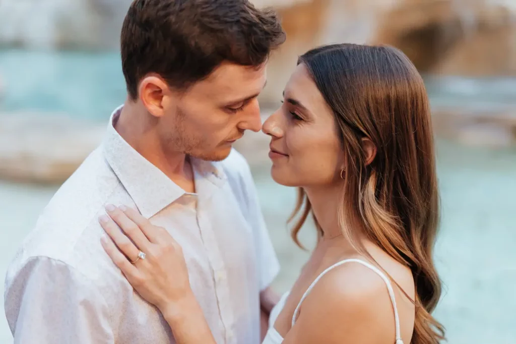 A couple standing close together and looking affectionately at each other.